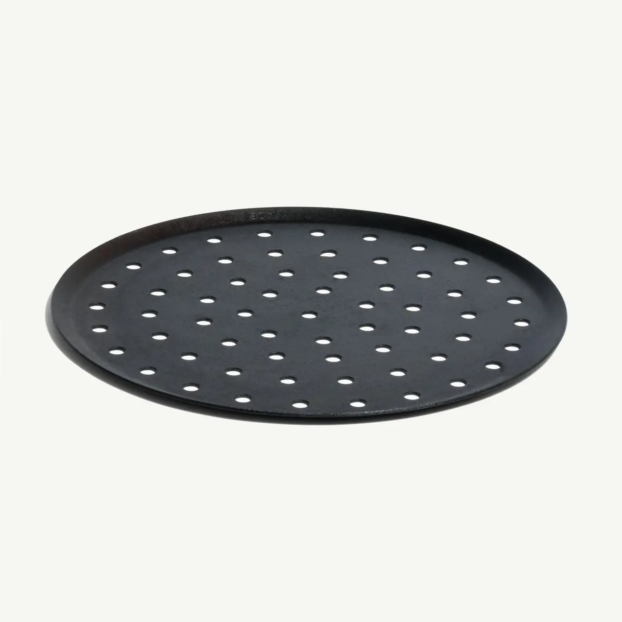 A black, circular metal pizza crisper with holes, isolated on a light background.