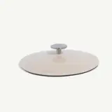 A white pot lid with a metal handle is centered against a plain background.
