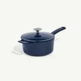 A dark blue saucepan with a lid and long handle is displayed against a plain background.