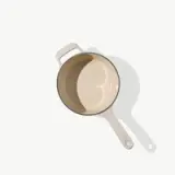 A beige pot with a handle is shown against a light background, casting a shadow.