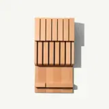 A stylish wooden knife block with a modern slatted design is shown.
