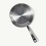 A stainless steel frying pan with a black handle is depicted against a light background.