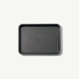A plain, rectangular, dark gray baking tray is centered on a light background.
