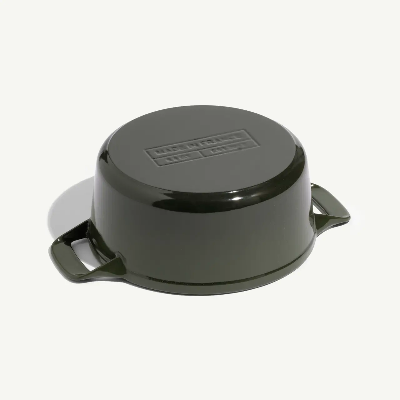 A dark green, round cooking pot with handles and a flat lid on top.