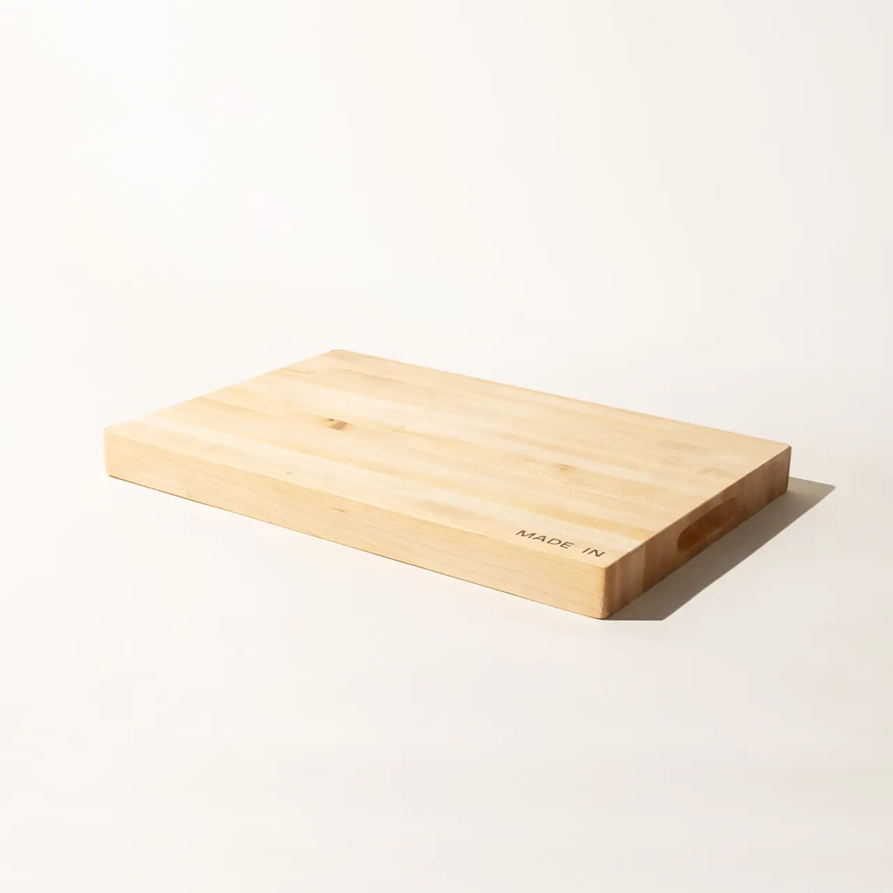 A plain wooden cutting board is displayed against a light background.