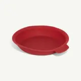A red, round silicone baking pan with a small handle on one side.
