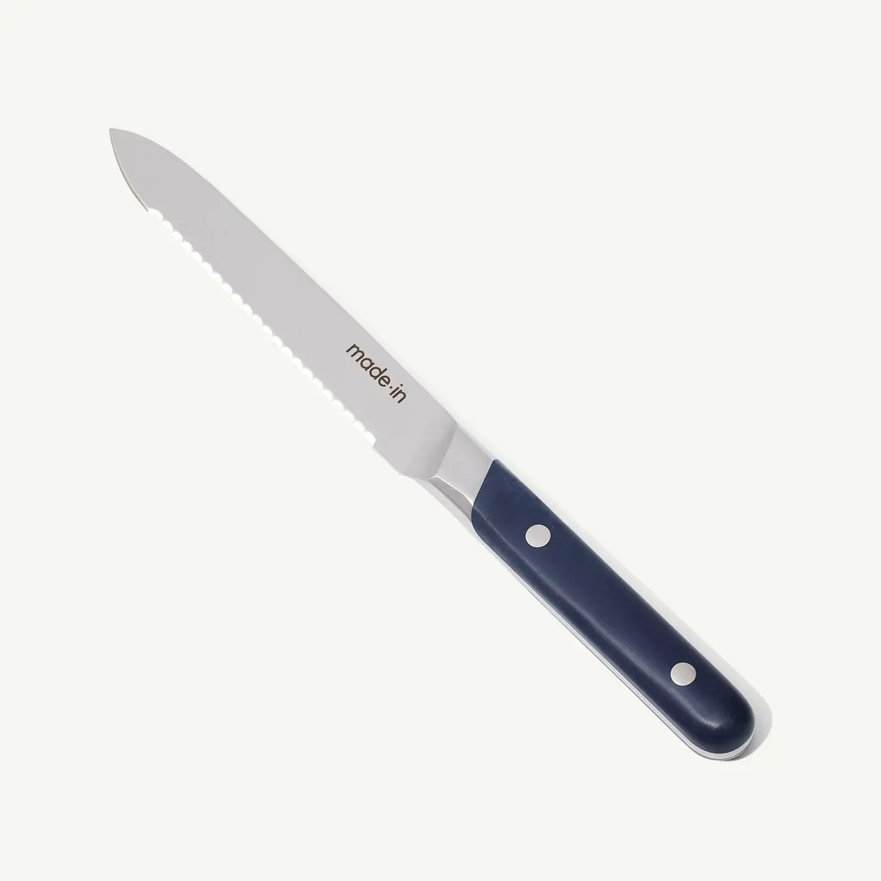 A serrated kitchen knife with a dark handle and two rivets against a plain background.