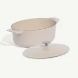 Large cream-colored pot with two handles and a matching lid resting beside it.