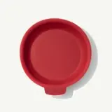 Bright red round silicone lid with a small handle labeled "MADE IN."