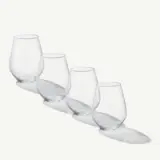 Four stemless wine glasses are arranged in a row with their shadows casting on a light surface.