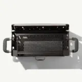 A top view of a modern, charcoal grill featuring a metal mesh cooking surface and sturdy side handles.