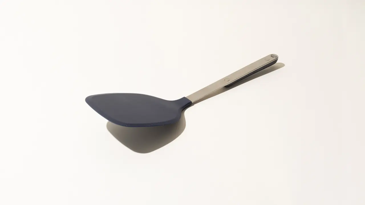 A silicone kitchen ladle with a stainless steel handle isolated on a white background.