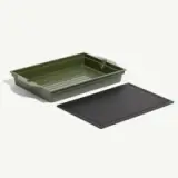 A green tray with ridges and a black flat lid sits beside it.