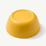 A bright yellow bowl is displayed upside down on a light background.