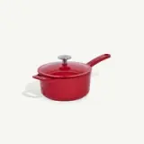 A red enameled cast iron saucepan with a lid and a long handle is shown against a plain background.