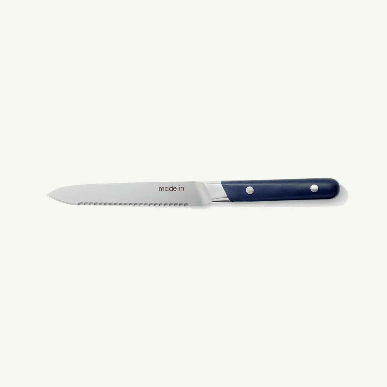 A serrated kitchen knife with a dark blue handle and two rivets.