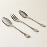 Two spoons and a fork are neatly arranged on a light background.