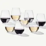 A collection of wine glasses filled with varying levels of red and white wine arranged in an artistic layout.