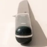 A close-up photo of a cylindrical device, possibly a digital thermometer or a small flashlight, casting a shadow on a light surface.