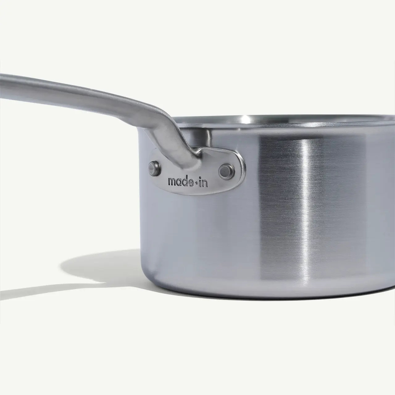 A stainless steel saucepan with a long handle and the brand name "Made In" engraved near the handle's base.