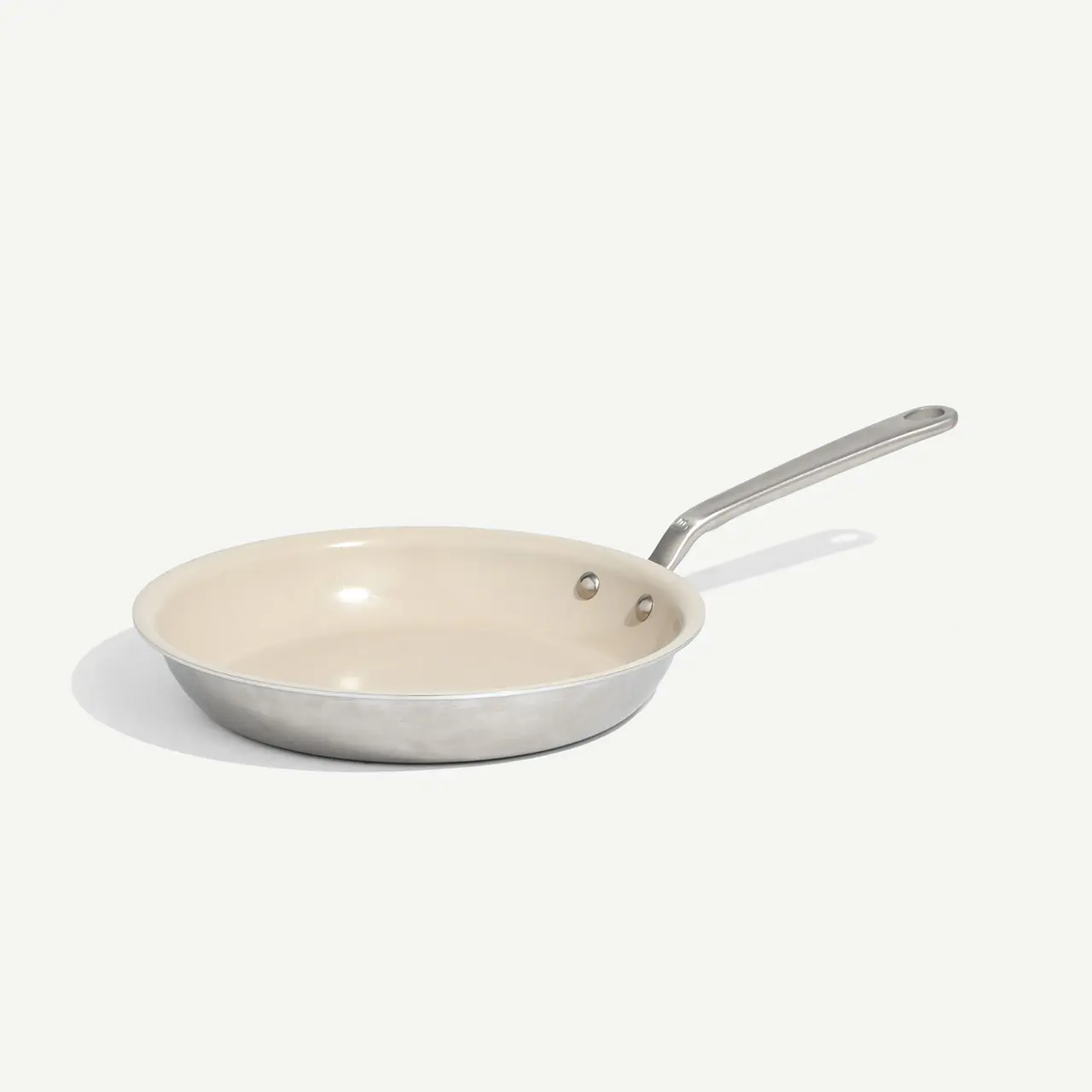 A non-stick frying pan with a stainless steel handle sits on a light background.