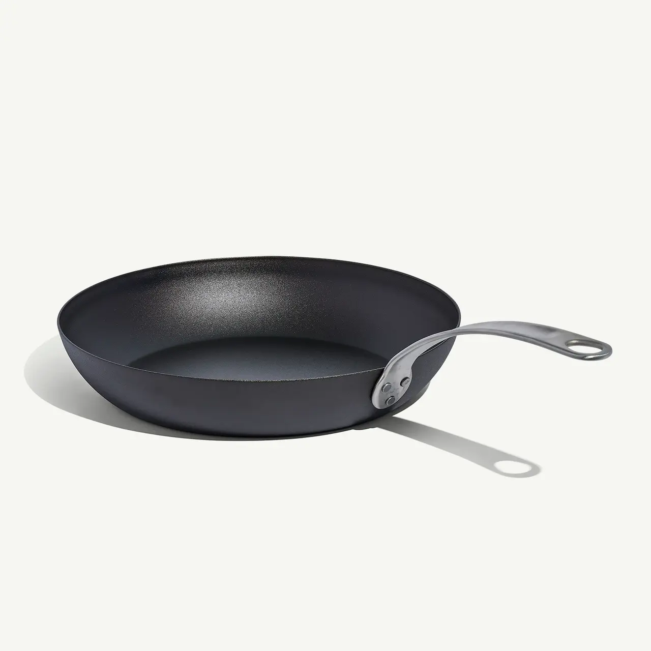 A black frying pan with a sleek, curved handle is shown against a white background.