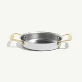 A shiny stainless steel pan with two golden handles, designed for cooking.