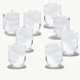 Several clear glasses filled with ice cubes are arranged on a light background.