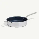 A stainless steel skillet with a dark non-stick interior and a long handle.