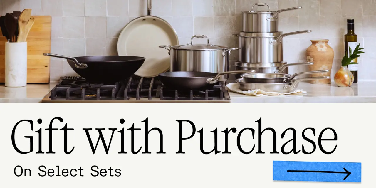 A modern kitchen countertop displays cookware sets with a promotional message for a "Gift with Purchase" on select items.