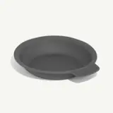 A dark gray, round silicone baking pan with a handle on one side.