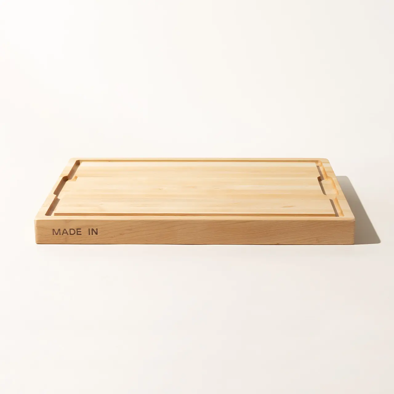 A wooden tray with "MADE IN" inscribed on one side is placed against a plain background.