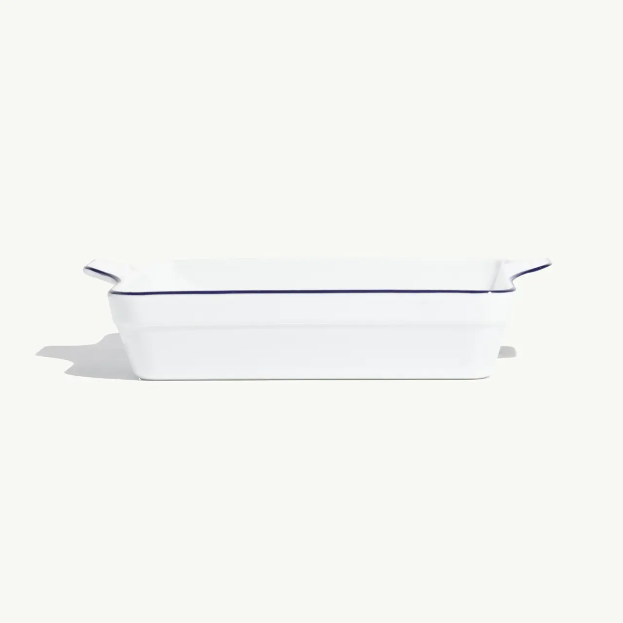 A white ceramic baking dish with blue trim is displayed against a light background.