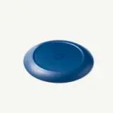 A blue, round frisbee lies flat on a neutral background.