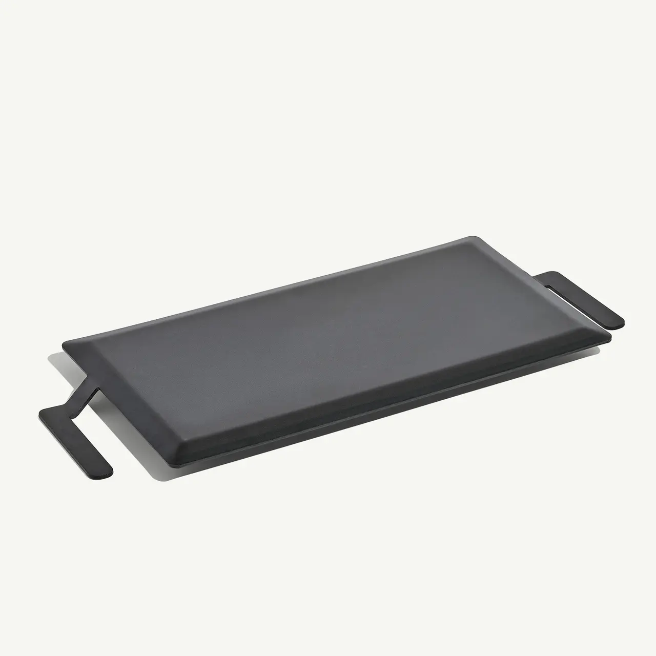 A rectangular black griddle with handles on both ends.