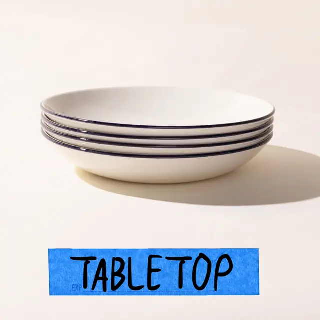 A stack of white plates with blue stripes on the side placed on a surface with the word "TABLETOP" written in blue on a label at the bottom.