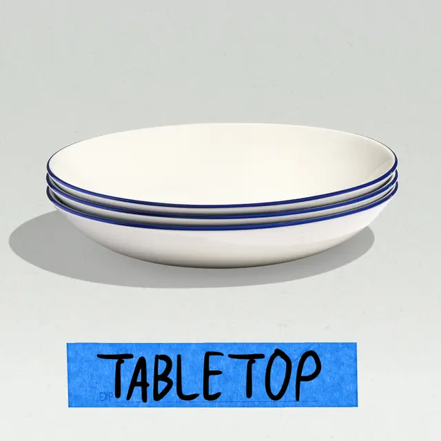 A stack of three white bowls with blue rims is placed on a light surface, accompanied by a blue labeled sign that reads "TABLE TOP."