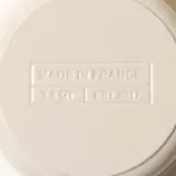 Close-up of the embossed bottom of a porcelain item with "Made in France" and additional markings indicating size and model year.