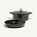 A green enameled cast iron pot with a lid is accompanied by a matching shallow skillet.