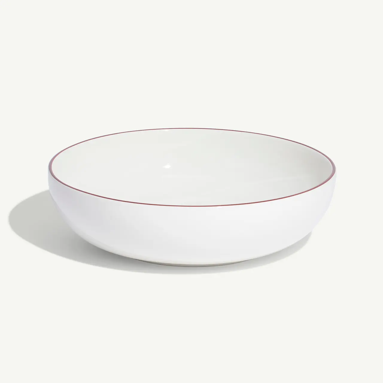 A white bowl with a thin red rim is placed against a plain background.