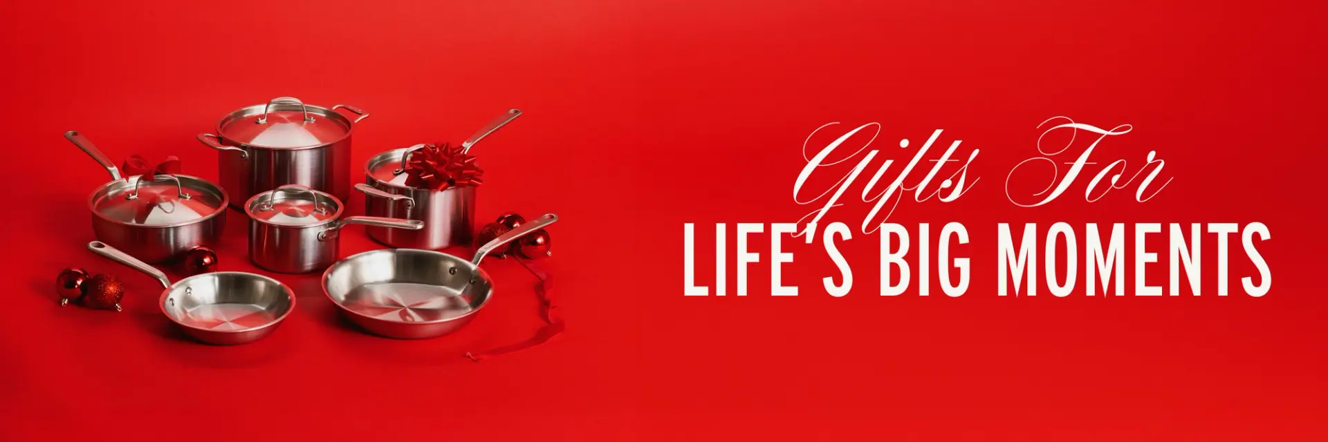 A collection of stainless steel cookware is displayed against a red background, accompanied by the text "Gifts For Life's Big Moments."