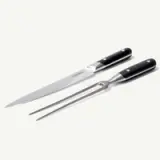 A sleek carving knife and fork set with stainless steel blades and black handles.