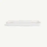 A rectangular white ceramic baking dish with red lining along the edges is displayed against a plain background.