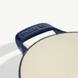 A close-up of a black cast iron skillet with "made.in" embossed on the handle.