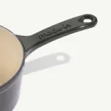 A dark-colored saucepan with a glossy finish and a handle that features the embossed text "made-in."