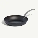 A black frying pan with a gray handle is shown against a white background.