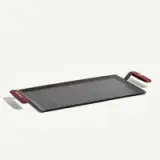 A flat griddle with red handles designed for cooking.