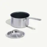 A stainless steel saucepan with a removable lid placed beside it.