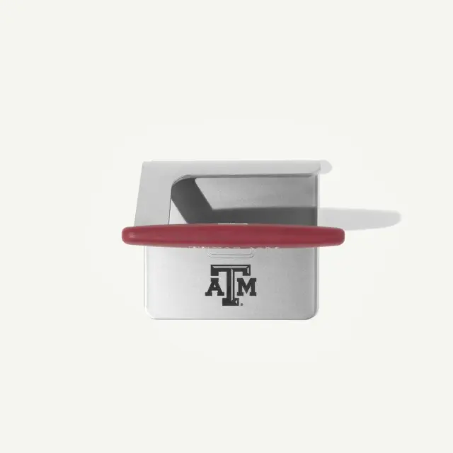 A silver metal device with a red handle prominently featuring the Texas A&M logo.