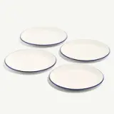 Four white plates with blue rims are arranged on a light background.